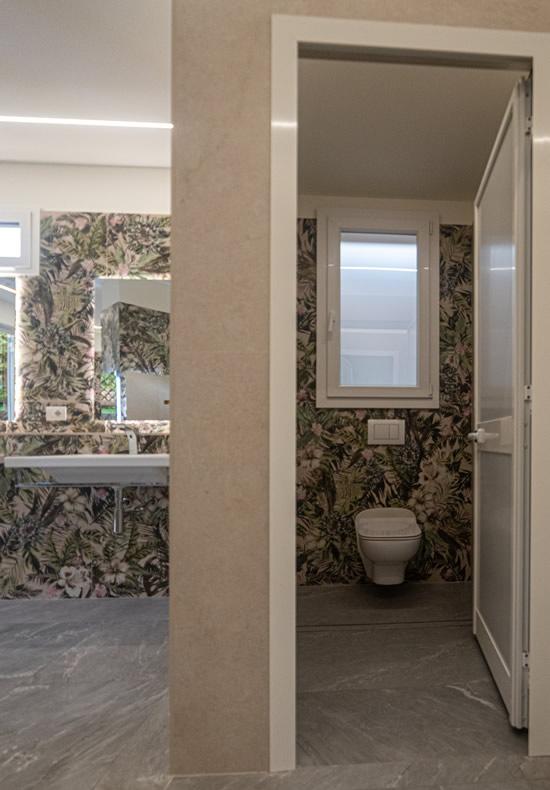 Moderne badkamer met bloemenbehang en helder raam.